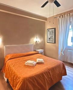Hotel Dali في فلورنسا: غرفة نوم مع سرير برتقالي مع منشفتين عليه