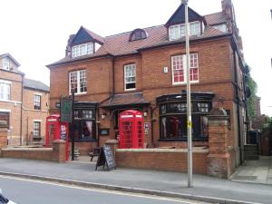 um edifício de tijolos com cabines telefónicas vermelhas numa rua em Fifteens of Swinley em Wigan