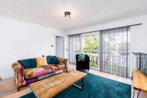 een woonkamer met een bank en een tafel bij 3 BR Chic Home with Balcony & Free Parking! in Leeds