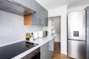 a kitchen with a counter with a microwave and a refrigerator at 3 BR Chic Home with Balcony & Free Parking! in Leeds