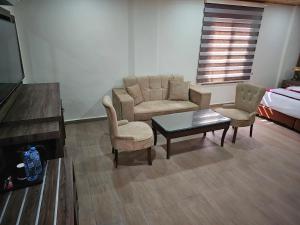 sala de estar con sofá, sillas y mesa en Sunset Hotel, en Wadi Musa