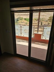 una puerta corredera de cristal con vistas a un balcón en Sunset Hotel, en Wadi Musa