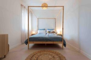 um quarto com uma cama de dossel e um tapete em Appartement T2 la perle bleue em Agde