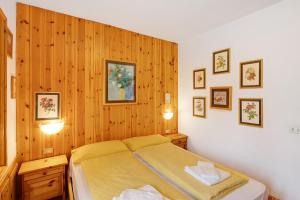a bedroom with a bed and a wooden wall at Residence Valleverde in Livigno