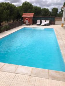 a large blue swimming pool with chairs and a gazebo at Monte Santo in Montargil