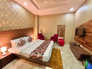 a bedroom with a bed and a flat screen tv at Hotel The Pearl, Zirakpur - A Luxury Family Hotel in Chandīgarh