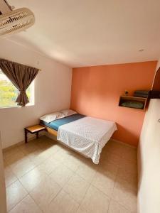 a small bedroom with a bed and a window at Finca hotel casa rosada in Tuluá