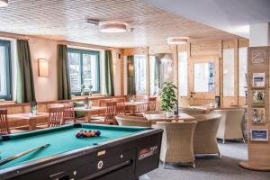 a pool table in a restaurant with tables and chairs at JUFA Hotel Bad Aussee in Bad Aussee