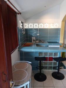 uma cozinha com dois bancos e um balcão azul em Studio proche aéroport 2perswifi em Matoury