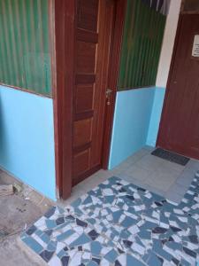 Zimmer mit einer Tür und Fliesenboden in der Unterkunft Studio proche aéroport 2perswifi in Matoury