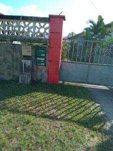 una scatola rossa seduta accanto a una recinzione di Studio proche aéroport 2perswifi a Matoury