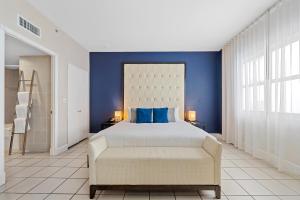 a bedroom with a bed and a blue wall at The Sagamore Hotel South Beach in Miami Beach