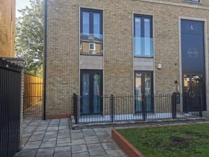 a brick building with a black fence in front of it at Cosy London Retreat - Sleeps 6 in London