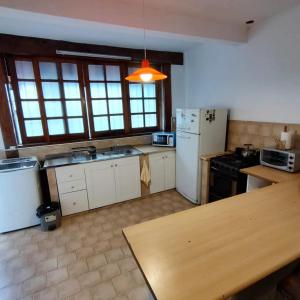 eine Küche mit einem weißen Kühlschrank und einem Tisch in der Unterkunft CASA PARA 4 PERSONAS, con asador y cochera in Cordoba