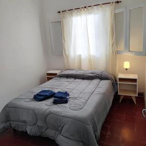 ein Schlafzimmer mit einem Bett mit zwei blauen Handtüchern darauf in der Unterkunft CASA PARA 4 PERSONAS, con asador y cochera in Cordoba