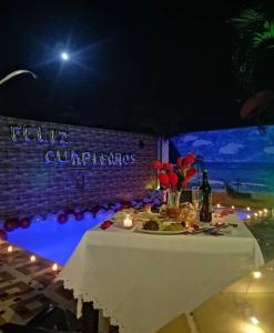 una mesa con un mantel blanco y velas en ella en Finca hotel casa rosada, en Tuluá