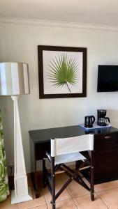 a desk with a chair and a table with a plant on the wall at Studio vue mer in Sainte-Anne
