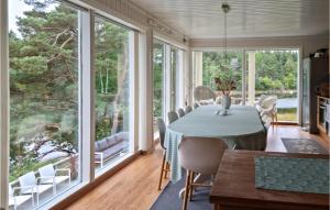 a dining room with large windows and a table and chairs at Cozy Home In Grimstad With House Sea View in Grimstad