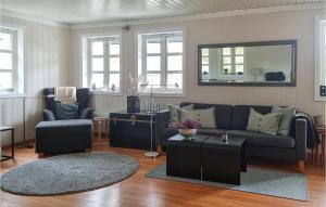 a living room with a couch and chairs and a mirror at Cozy Home In Grimstad With House Sea View in Grimstad