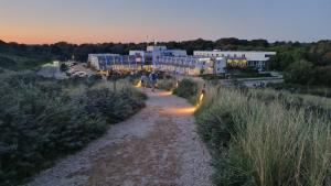 a couple of people walking down a dirt road at Strandhotel Westduin in Koudekerke +59 photos