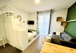 - un petit salon avec un canapé et un lit dans l'établissement Ho Toulouse Joli Studio rénové, à Toulouse
