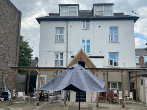 um edifício branco com um guarda-chuva em frente em Aron Guest House em Ealing