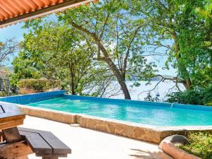 uma grande piscina num quintal com árvores em Villas at Gone Fishing Panamá Resort em Boca Chica
