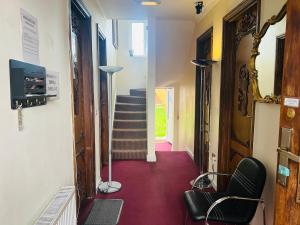 a hallway with a red floor and a stair case at Aron Guest House in Ealing