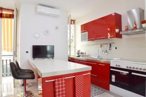 uma cozinha com armários vermelhos e um balcão branco em “La Casa di Margi” em Nápoles