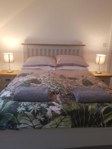 a bedroom with a bed with two lamps on two tables at Luxury Holiday Home in St. Leonards