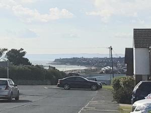 a car parked in a parking lot with a view of the ocean at Luxury Holiday Home in St. Leonards