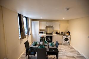 Remarkable 3-Bed Apartment in London في لندن: مطبخ مع طاولة وكراسي في غرفة