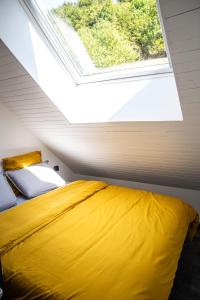 a bedroom with a large yellow bed and a window at Bienvenue dans l'ambre 2 à 7 couchages in Cholonge
