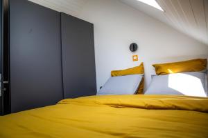 a bedroom with a yellow bed and yellow pillows at Bienvenue dans l'ambre 2 à 7 couchages in Cholonge