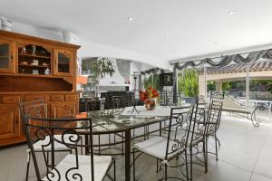 ein Esszimmer mit Glastisch und Stühlen in der Unterkunft Maison au Soleil d'Azur in Fréjus