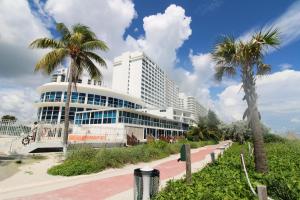 Un gran edificio con palmeras delante. en Castle 1118 Studio BayView Direct Beach Access, Tennis, Pool, Restaurants, Free Parking, en Miami Beach