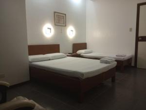 a room with two beds in a room at Citywalk Hotel in Dumaguete