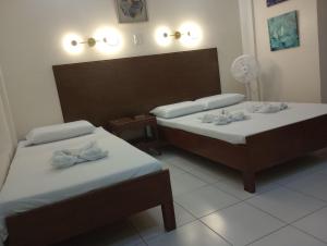 Habitación con 2 camas y ventilador. en Citywalk Hotel en Dumaguete
