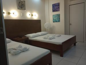 a hotel room with two beds and a mirror at Citywalk Hotel in Dumaguete