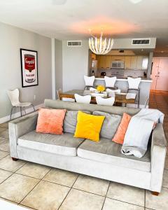 sala de estar con sofá gris y almohadas coloridas en Castle Pavillon 8 Beachfront - Private Beach Access Loft with 2-story, Pool, Tennis, Free Parking Access, en Miami Beach