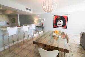 a dining room with a table and white chairs at 2-story Loft Beachfront Condo for up to 8 guests, Free Parking and Beach Access in Miami Beach