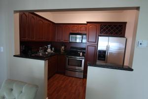 a kitchen with wooden cabinets and stainless steel appliances at 2 BD Penthouse with Balcony in Miami Beach