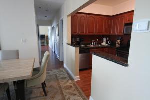 a kitchen with wooden cabinets and a wooden table at 2 BD Penthouse with Balcony in Miami Beach