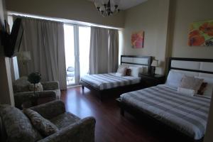 une chambre d'hôtel avec deux lits et un canapé ainsi qu'un salon dans l'établissement 2 BD Penthouse with Balcony, à Miami Beach