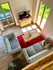 a living room with a couch and a table at DIE ZWEI CHALETS AM TEGERNSEE "s' Gloane" & "s' Große" in Rottach-Egern