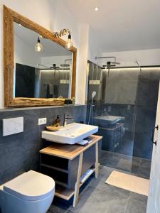 a bathroom with a sink and a toilet and a mirror at DIE ZWEI CHALETS AM TEGERNSEE "s' Gloane" & "s' Große" in Rottach-Egern