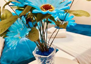eine blaue Blume in einer blauen Vase auf einem Tisch in der Unterkunft Residenciais Maria Flor in Gramado