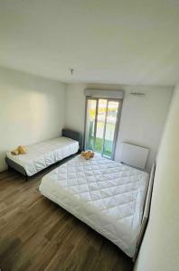 sypialnia z 2 łóżkami i oknem w obiekcie Appartement T2 + parking privatif - Centre ville w Bajonnie