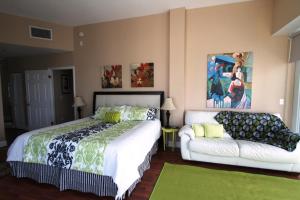 een slaapkamer met een bed en een bank bij Castle PH15 Spacious Penthouse with Balcony, Beach Access, Pool, Tennis, Free Parking in Miami Beach +119 foto's
