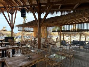 a restaurant with tables and chairs and straw umbrellas at Luxury Apartment - San Pietro in Durrës